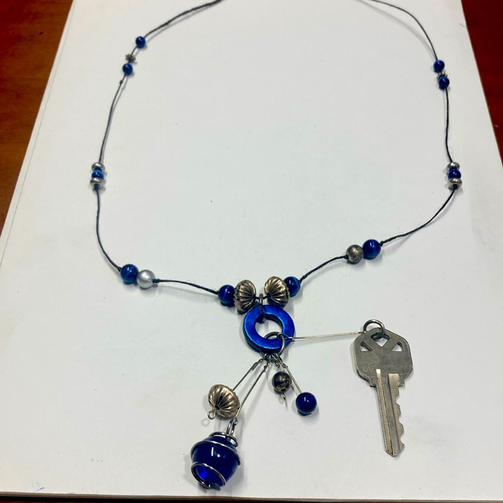 Handmade beaded and charmed necklace in blue and silver. Original design